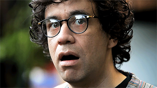 Curly haired man's mouth widens in surprise