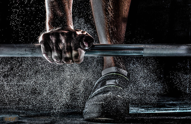 Foot shot of man lifting a dumbbell off the ground
