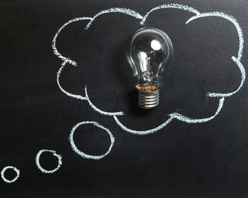 Lightbulb, chalkboard with thought cloud