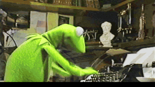 The Muppets TV series character, Kermit the Frog, typing on a typewriter