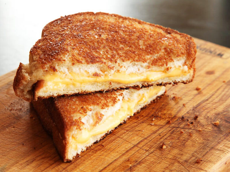 Photo of grilled cheese sandwhich on wooden cutting board