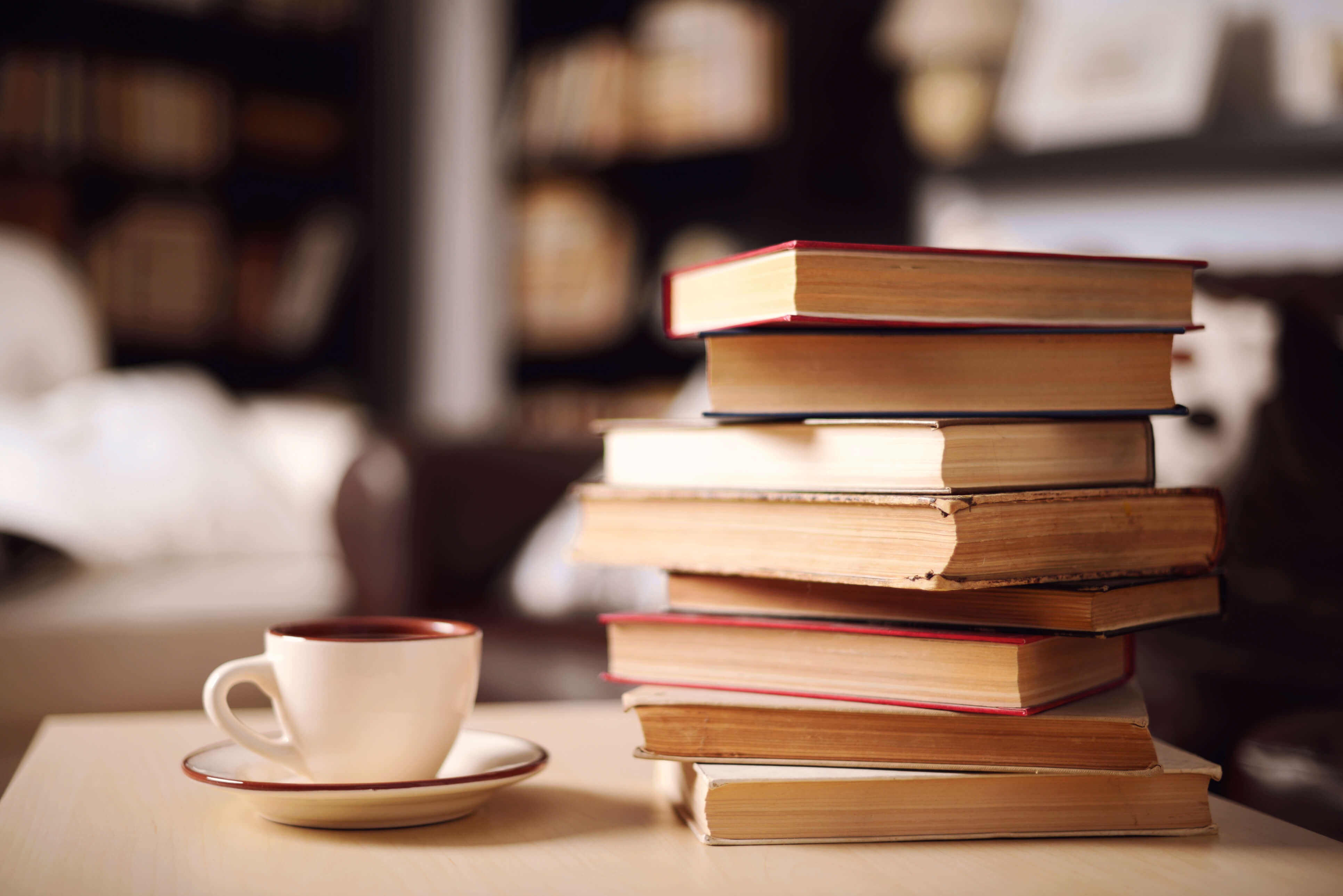 stack of books with cup of coffee on table
