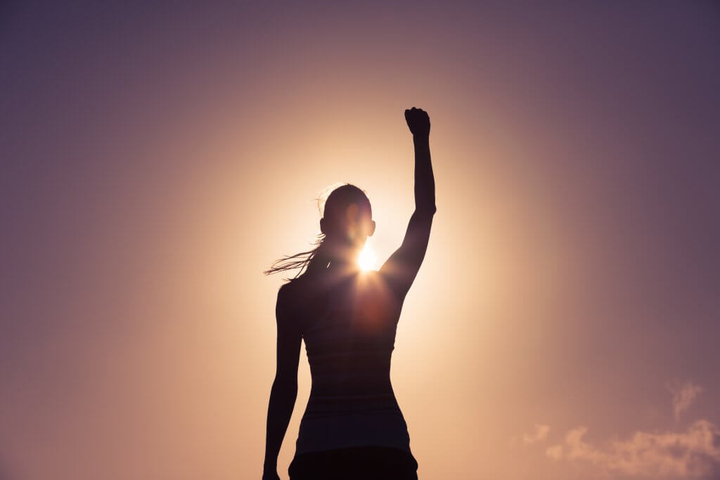 women standing in light with her arm up
