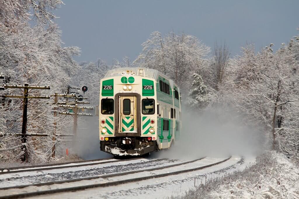 GO Train coming down the tracks toward the camera on a snowy winter day.
