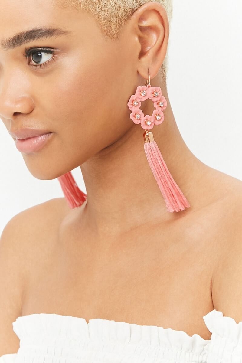 Woman wearing pink floral tassel earrings