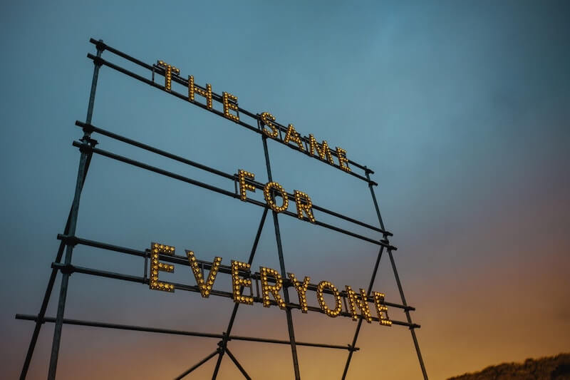 light sign with sky in background reading "THE SAME FOR EVERYONE"