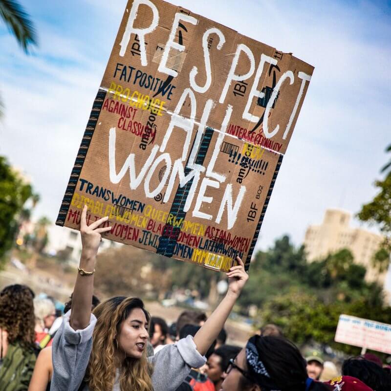 Woman holding sign reading "respect all women"