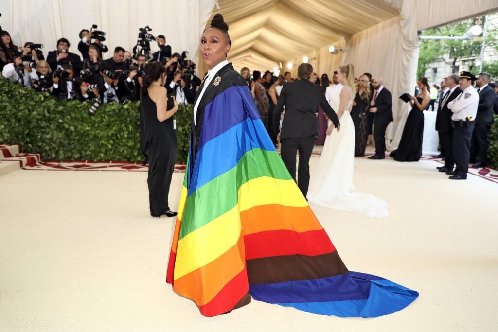 Lena Waithe wears Pride flag inspired cape on Met Gala red carpet with photographers in background