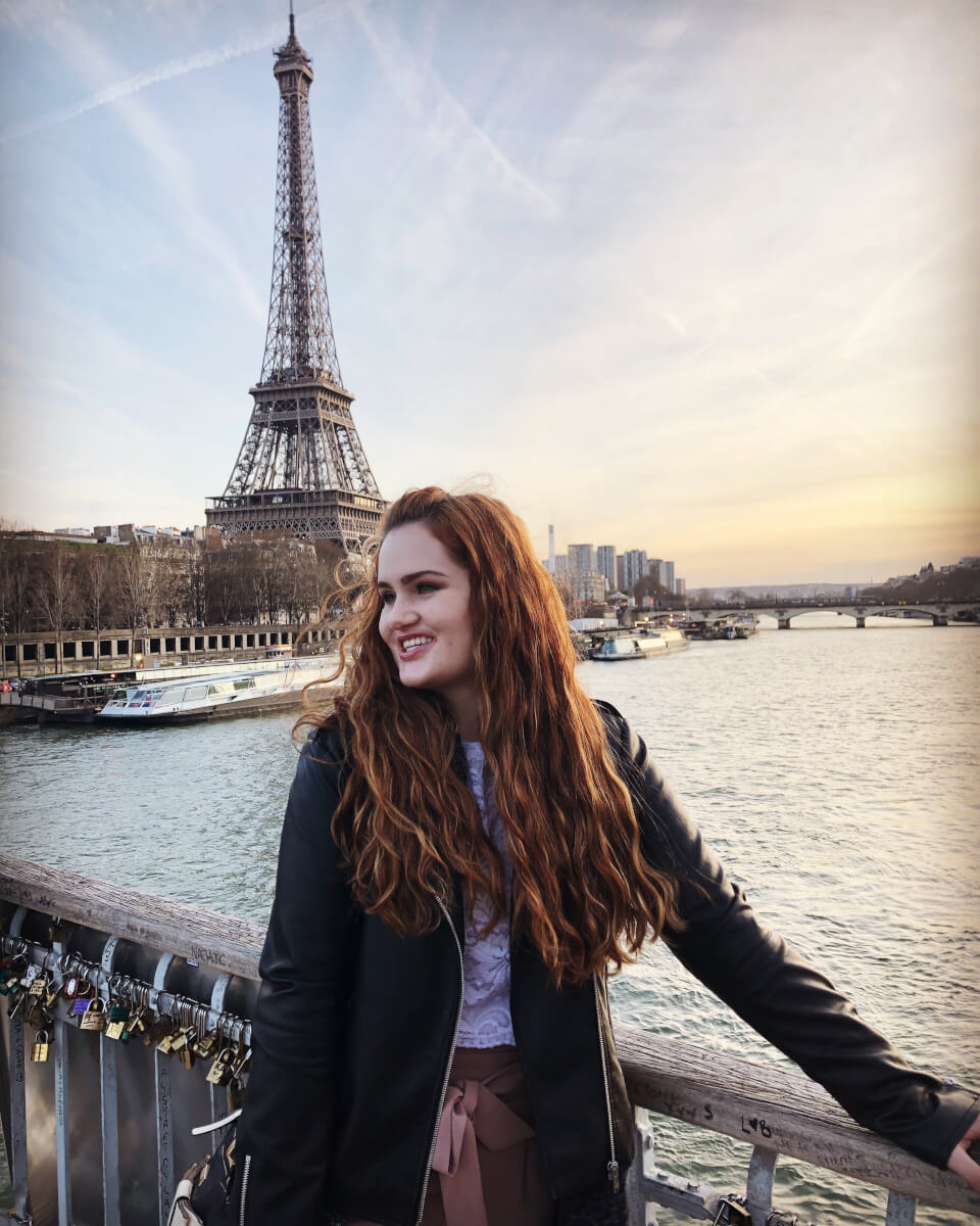 Maegan standing on front of the Eiffel Tower 