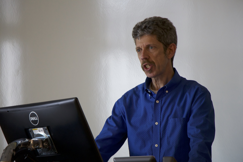 Man speaking in front of computer