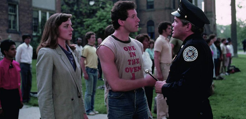 Image of character approaching police officer in the film Police Academy