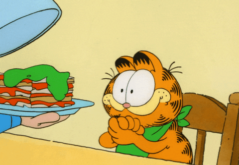 Gif of Garfield licks his lips and rubs his paws together while being served a plate of lasagna.