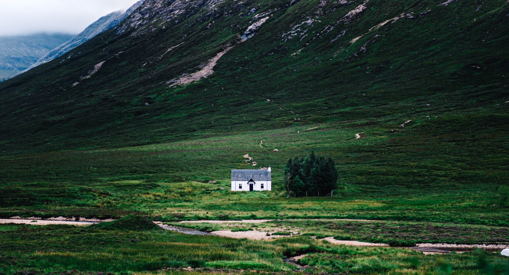 A small cabin sits alone in a desolate valley.