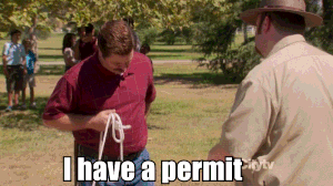Ron Swanson from Parks and Recreation hands a park ranger a slip of paper that says, "I can do what I want."