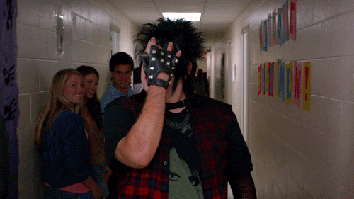 Jonah Hill as Schmidt in, "22 Jump Street," dressed as a goth walks down a hallway and brushes his bangs out of his face.