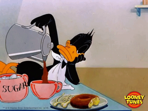 Daffy Duck from "Looney Tunes" pours hot coffee into a mug while resting his head on his hand next to a plate with a doughnut.