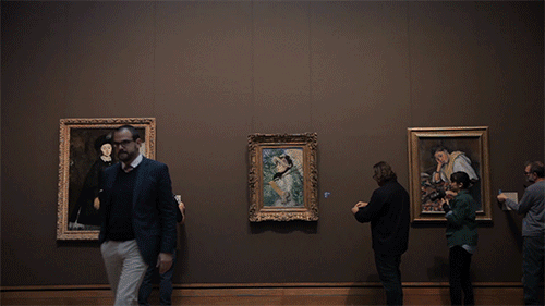 Time-lapse of patrons at an art museum walking past various paintings.