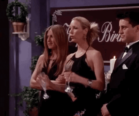 Phoebe from Friends holding champagne saying "woooo"