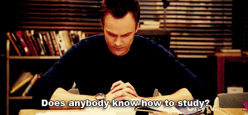 Joel McHale as Jeff Winger on NBC's "Community" (2009-2015) sits at a desk and says, "Does anybody know how to study?"