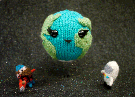 Stop motion animation of planet Earth hugging two humanoid creatures. Both the creatures and Earth are made out of yarn. Earth had large black eyes with distinguished eyelashes and a small smile.