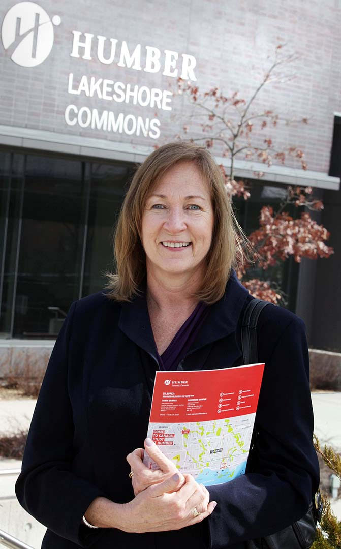 Mary Lee, program co-ordinator for Humber College's Alternative Dispute Resolution program, holds a red folder and smiles at the camera.