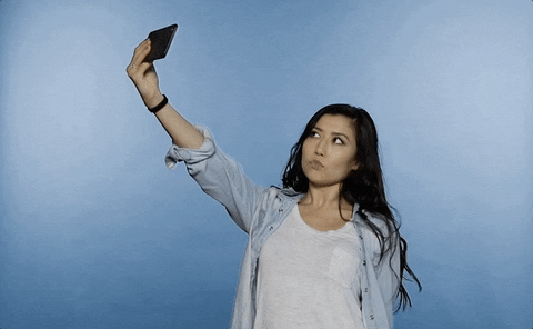 A woman taking a selfie with her arm outstretched.