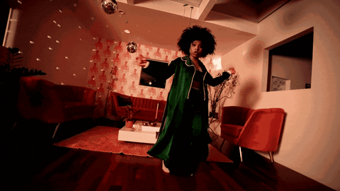 A woman wears pyjamas and dances in her living room.