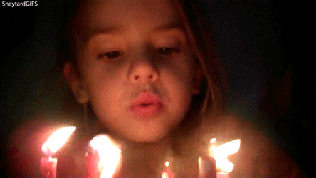 A child blows out anniversary candles.