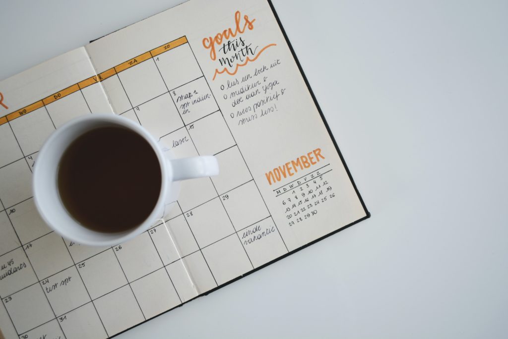 Agenda and coffee cup on desk