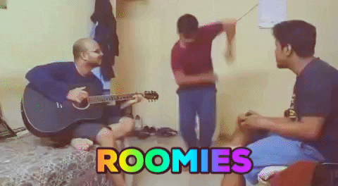 Roommates dancing and playing music together.