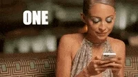 Nicole Richie checks her phone and puts a finger up as if to say, "One sec."