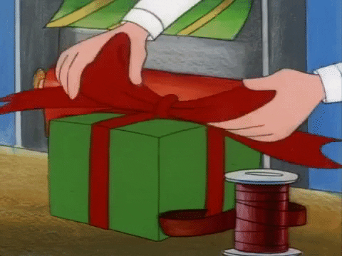 Hands touch up a bow on a gift-wrapped box.