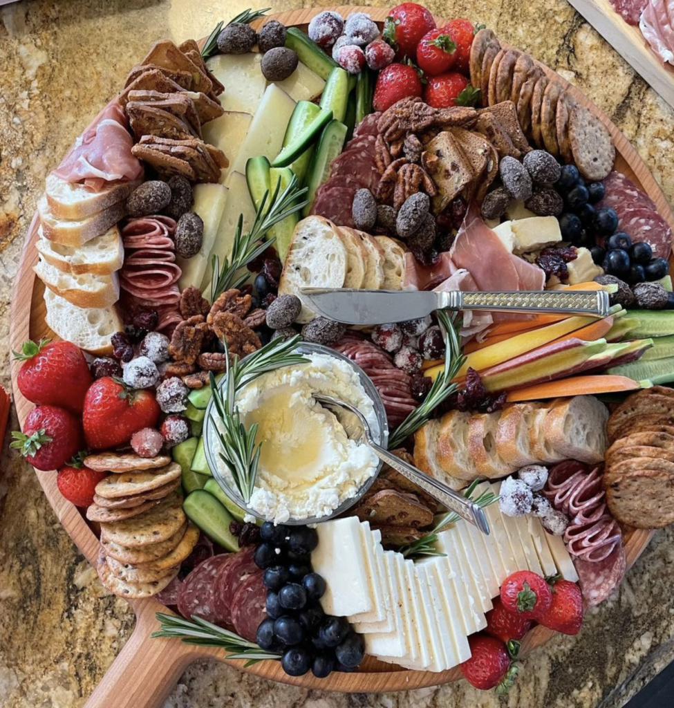 Charcuterie board with crackers, cheese, fruit and nuts.  
