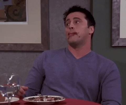Matt LeBlanc sits next to an empty plate of chocolate cake and licks his lips.
