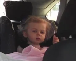 Little girl resting her head on the car seat in annoyance.