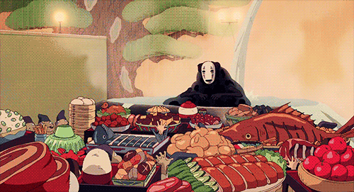 No Face from Spirited Away celebrating a feast with various dishes.