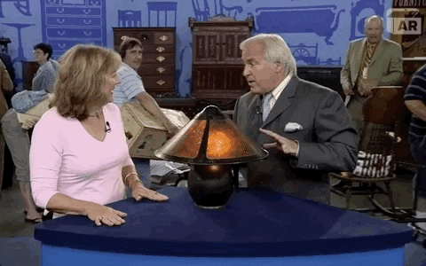 Host on Antique Roadshow saying, "It could go for double, triple that" to a woman with a lamp.