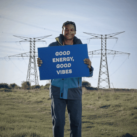 Man dancing with a sign that says "Good Energy, Good Vibes."