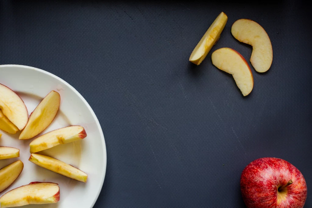 Apple slices on a plate with a black background.