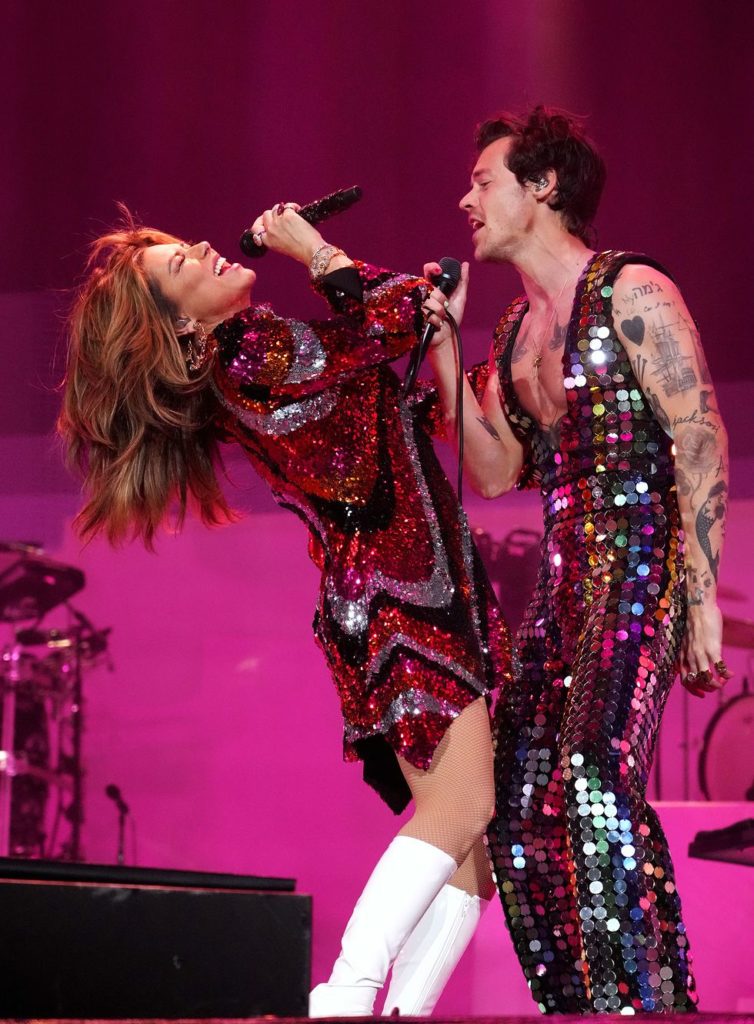 Harry Style and Shania Twain dressed in fashion outfits at Coachella.
