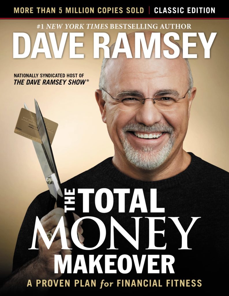 Dave is dressed in a t-shirt while holding a scissors that's cutting a credit card. He is on the cover of his book "The Total Money Makeover".