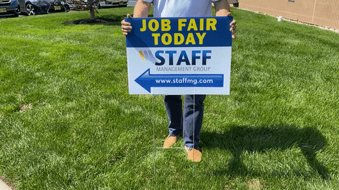 Someone is placing a sign which signs "job fair today."