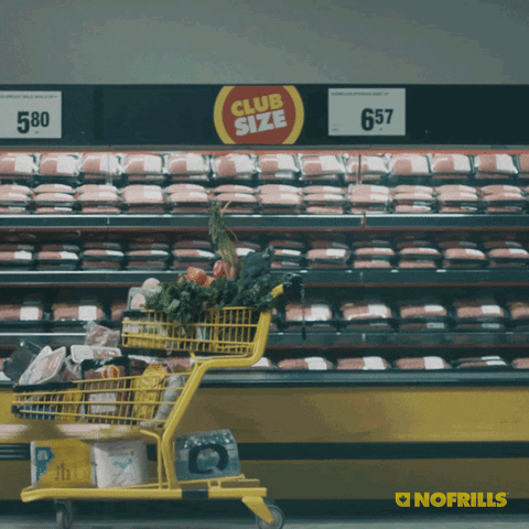 A guy is leaping and throwing items in a No Frills cart.