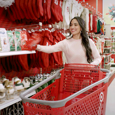 A lady is smiling while filling her carts with many items.
(organize)