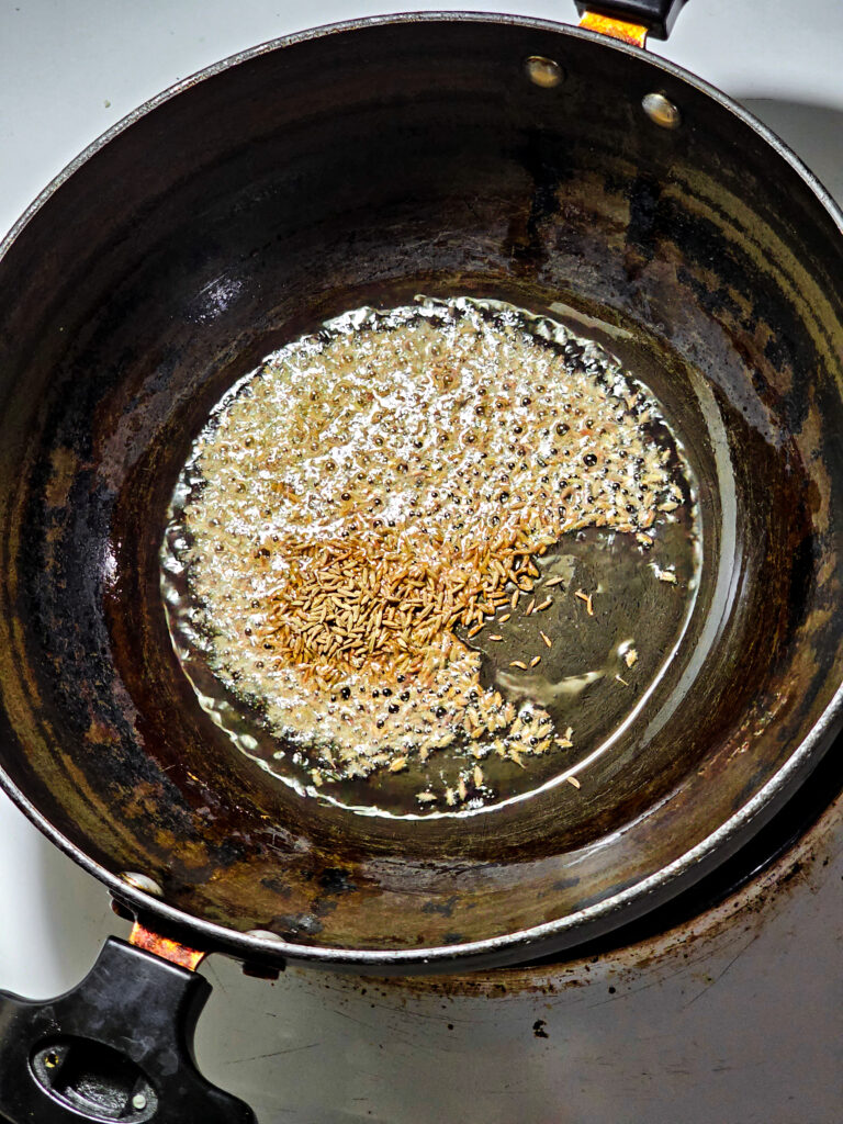 Cumin seeds popping in a pan