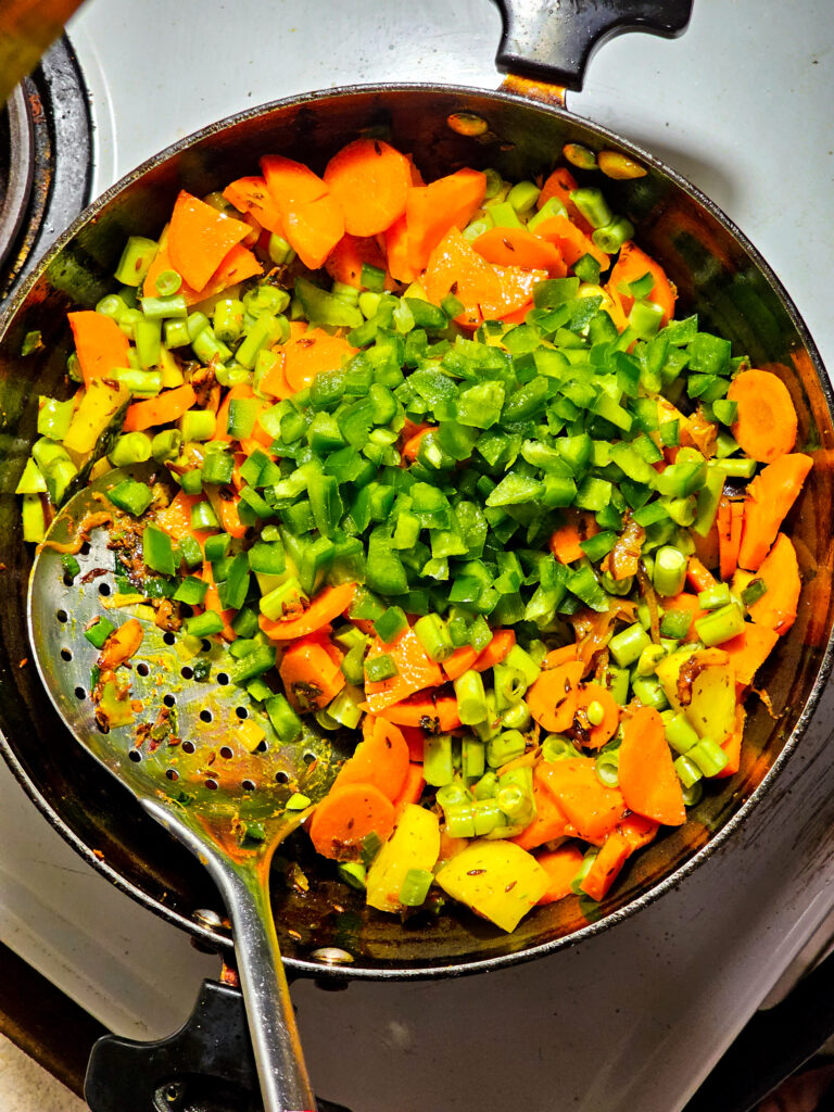 green capsicum added to a pan