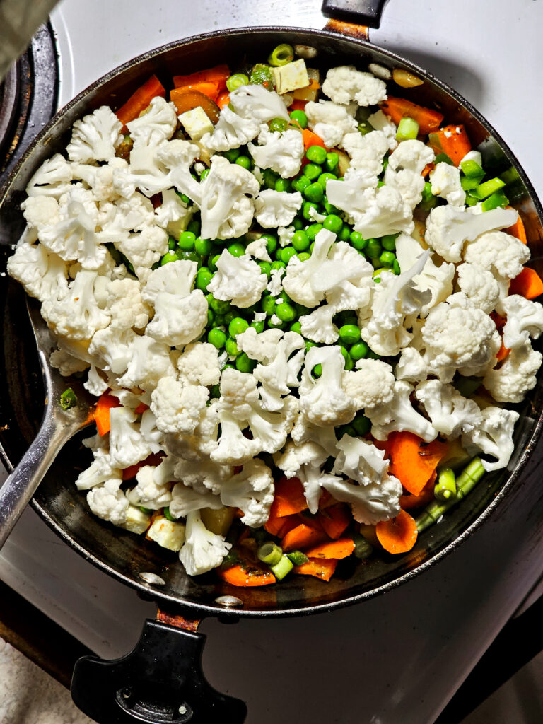 Cauliflower added to a pan