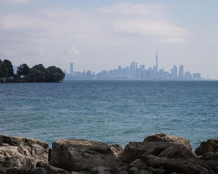 The waters of Lake Ontario are blue and calm. Downtown Toronto can be seen in the background.