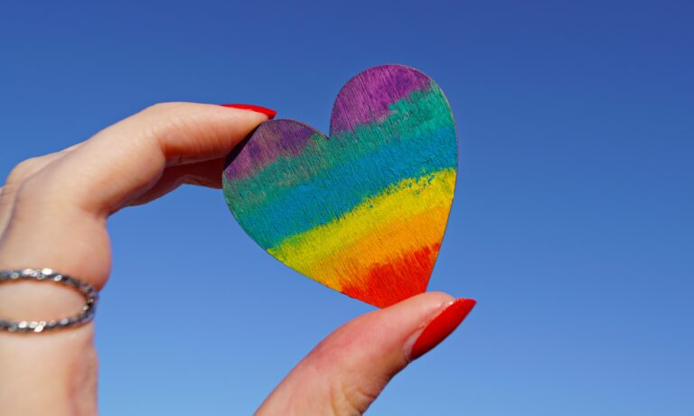 person holding multicoloured heart