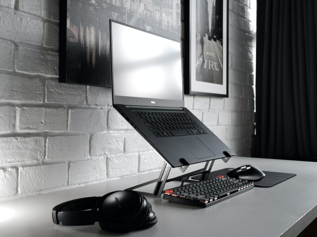 A Dell laptop is resting on a laptop stand. (desk)